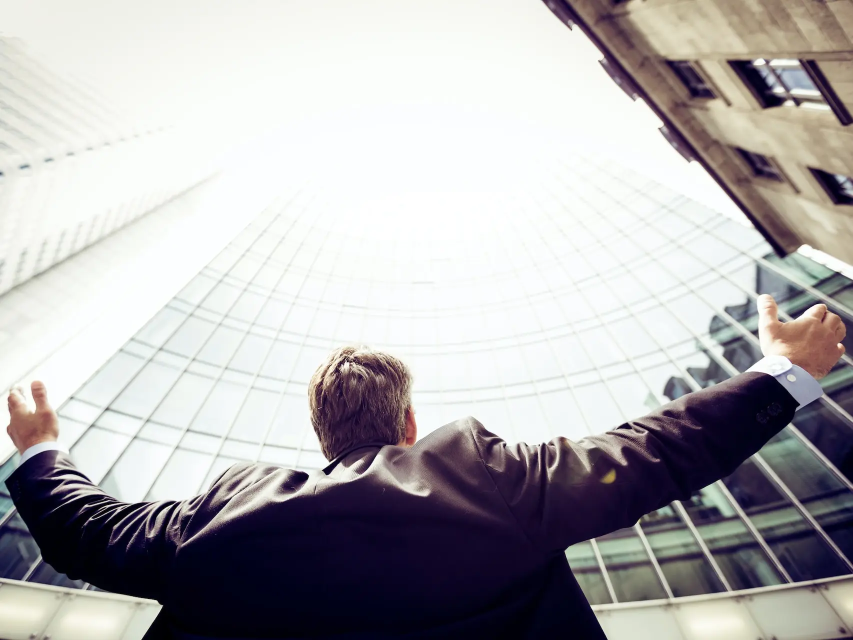 low-angle photography of man in the middle of buidligns
