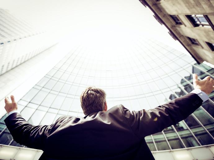 low-angle photography of man in the middle of buidligns